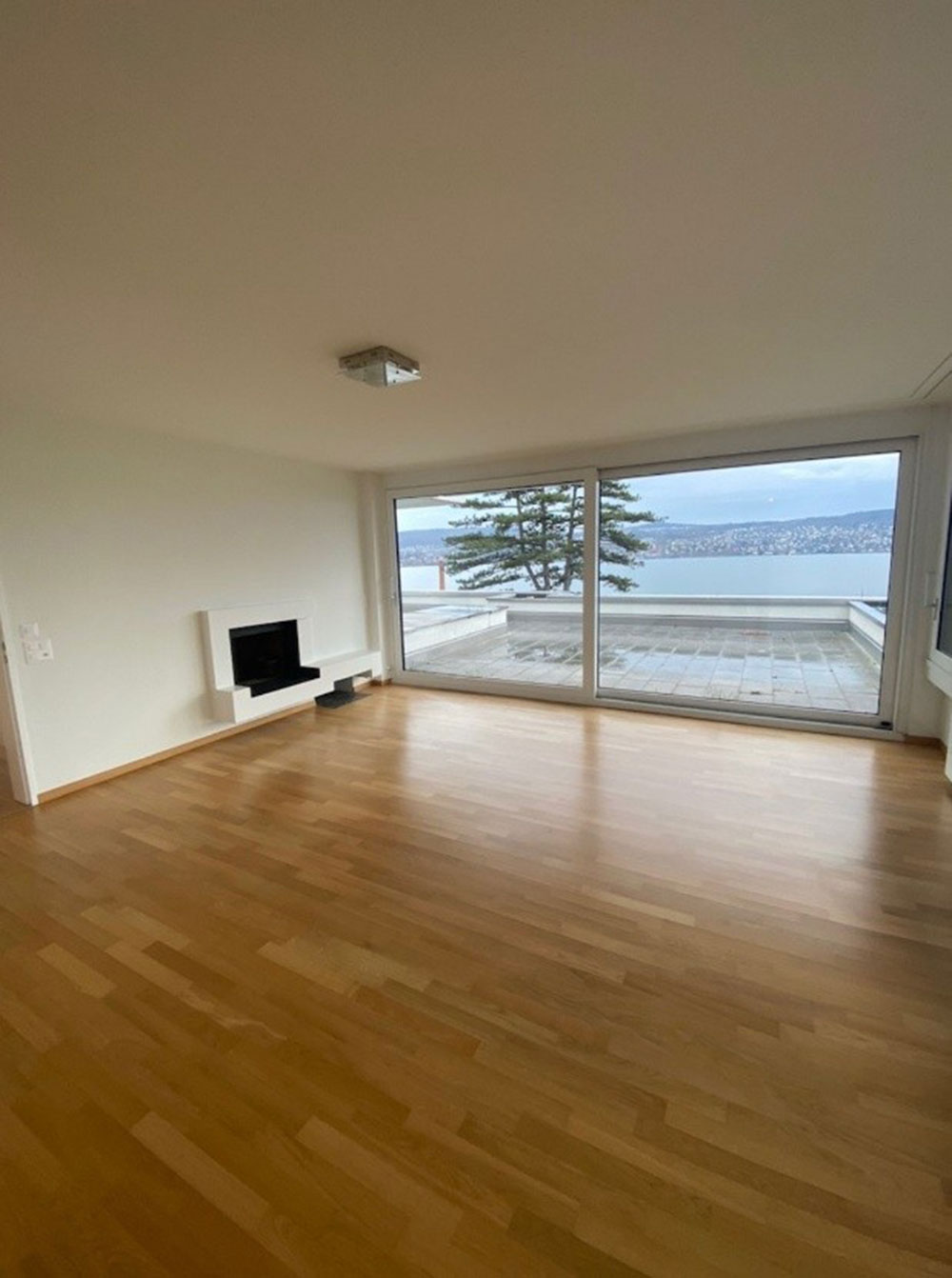 Helles-Wohnzimmer-mit-Parkettboden-und-grosser-Fensterfront-mit-Blick-auf-den-Zürichsee-–-frisch-gestrichene-Wände-und-Decke-durch-Maler-Freunde-GmbH